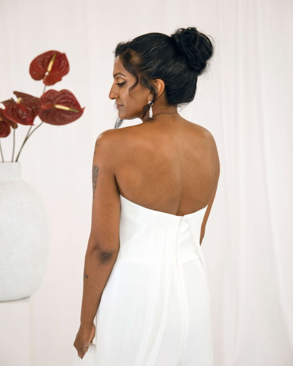 Braut von hinten mit Hochsteckfrisur und trägerlosem Brautkleid